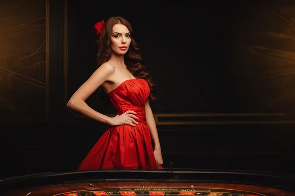 A young woman relaxing with her phone while dynamic casino elements float around her, illustrating the smooth mobile experience offered by the BA98 app.